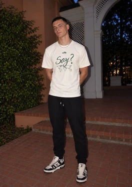 The Say? tee worn at an angle, with its green artwork visible